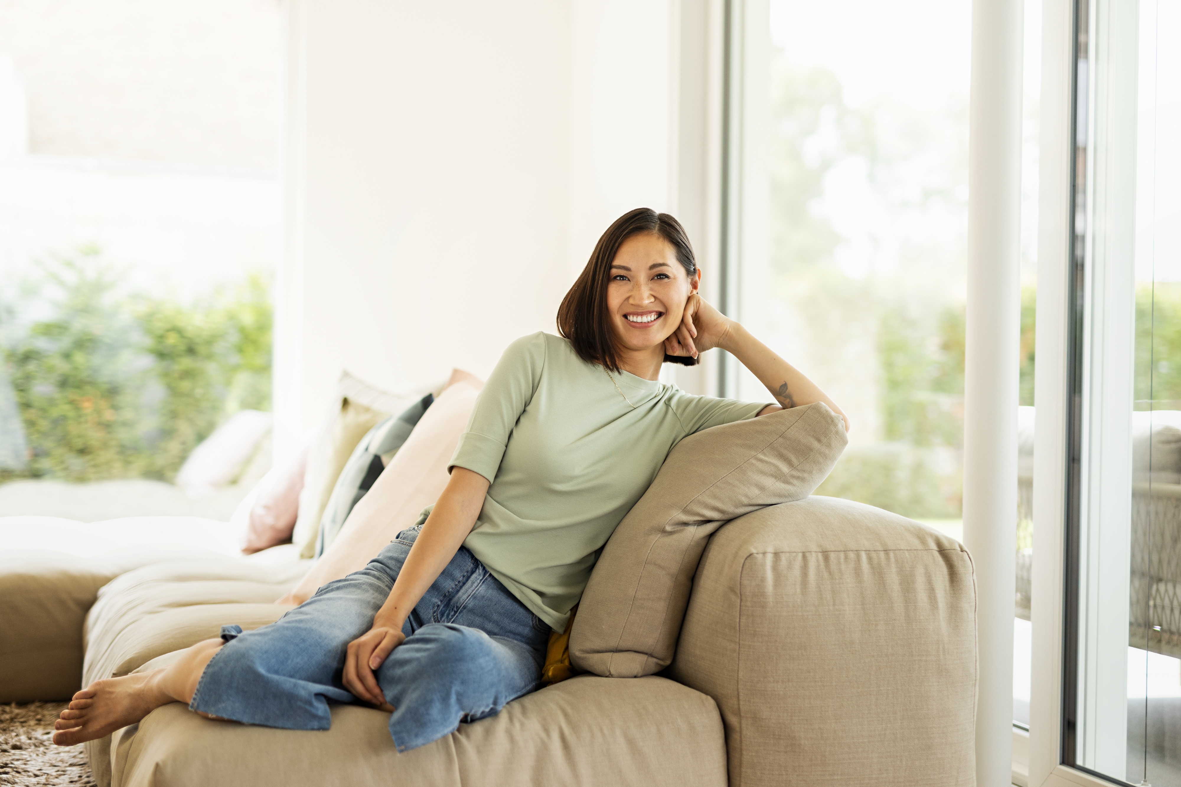 Donna sorridente seduta sul divano