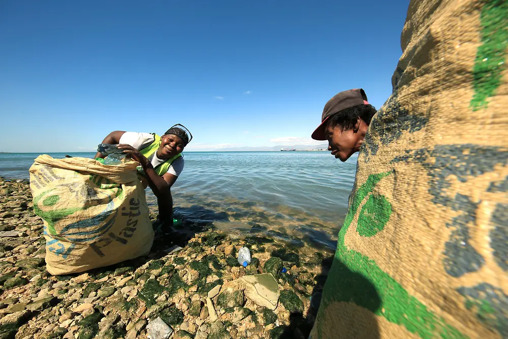 Progetto Plastic Bank: due persone raccolgono plastica su una spiaggia
