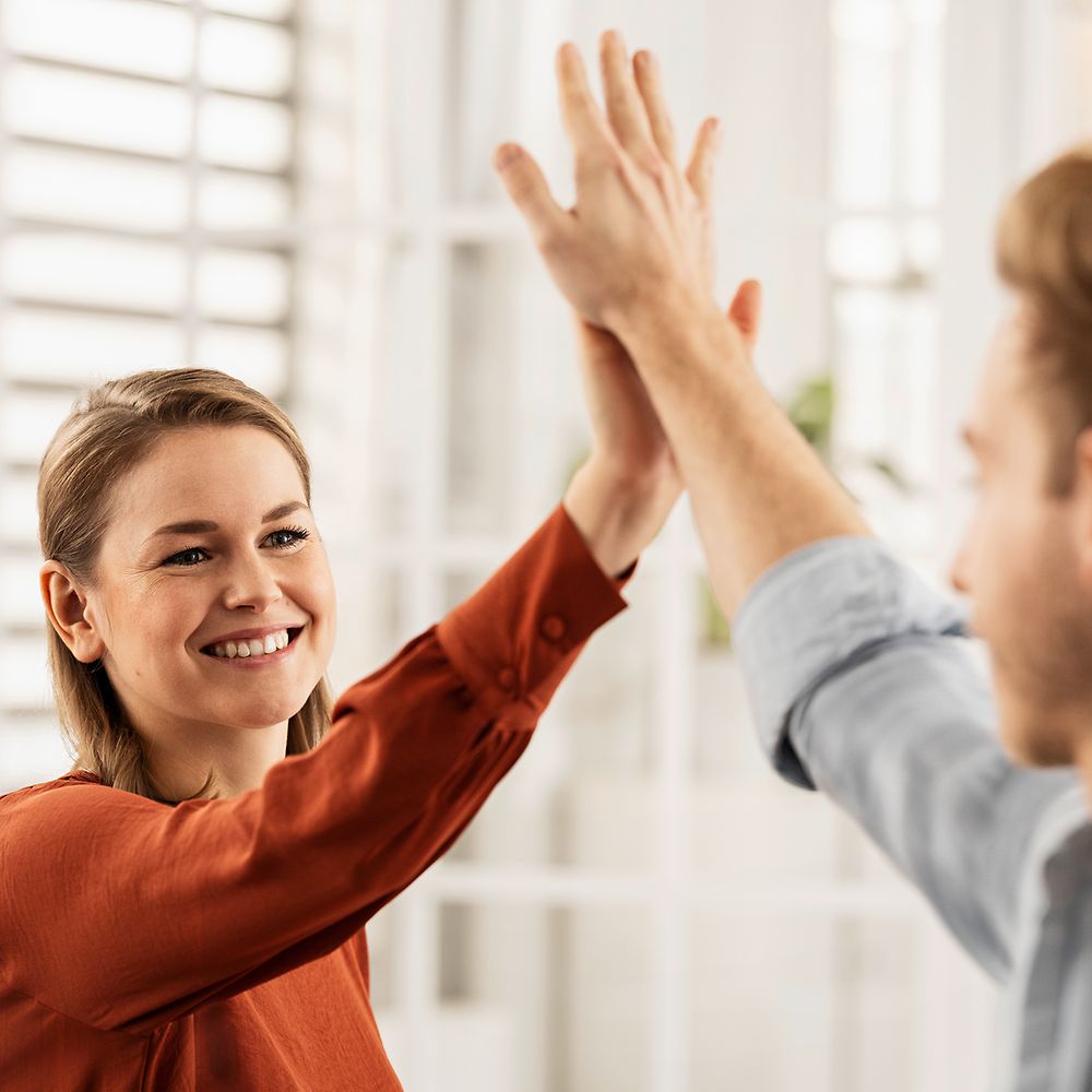 Friendly colleagues give each other a high five. 