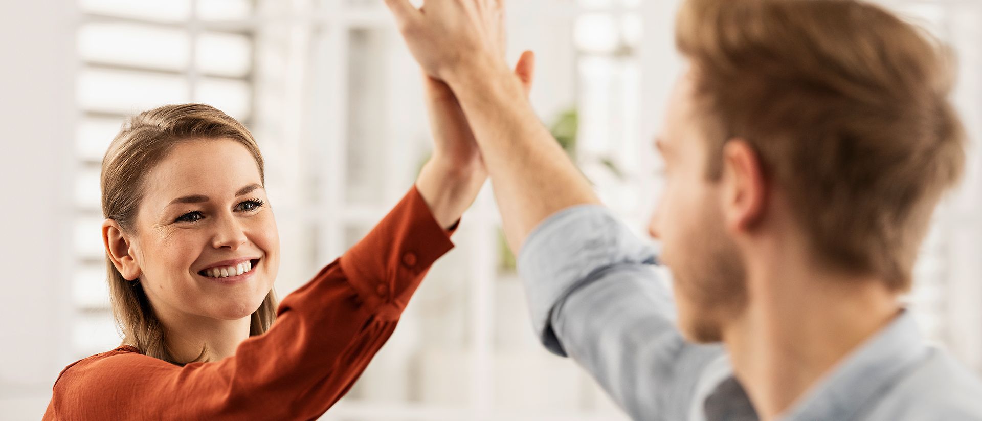 Friendly colleagues give each other a high five. 