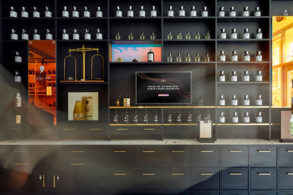 A dark wall of shelves with golden handles that display a variety of Schwarzkopf products. 