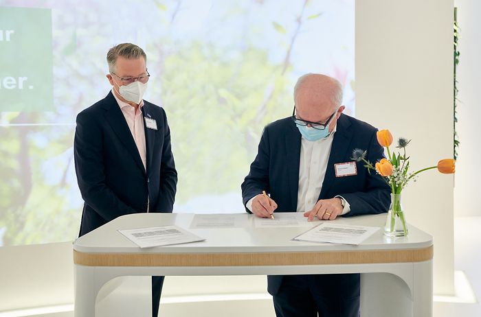The two representatives of BASF and Henkel are signing the contract. 