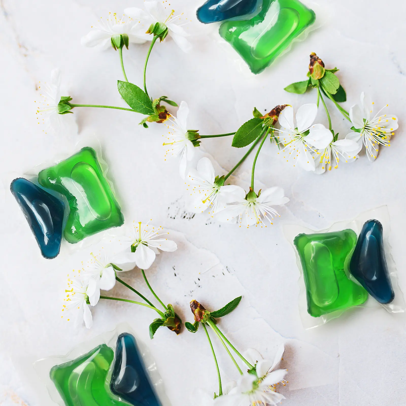 Due tab di Persil verdi e blu circondate da fiori di ciliegio
