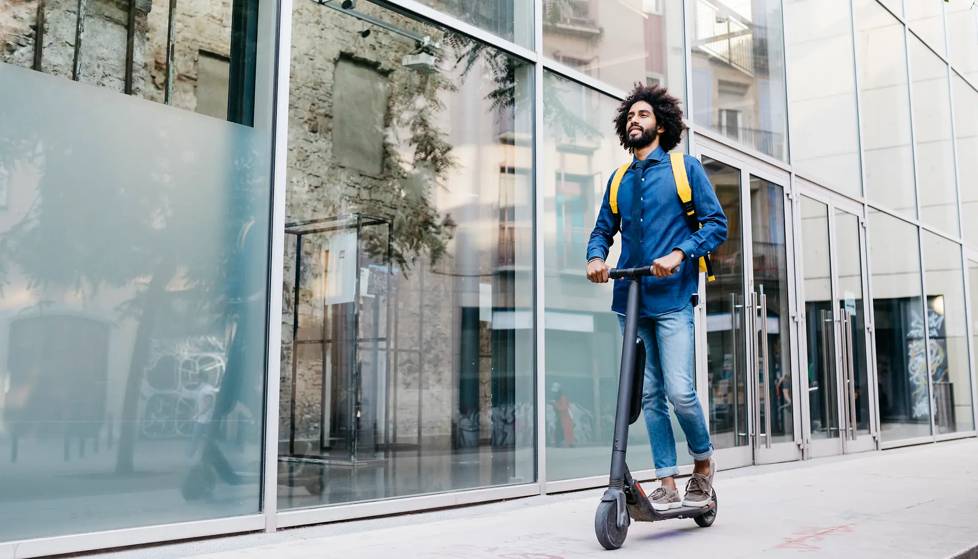 Uomo in città su scooter elettrico